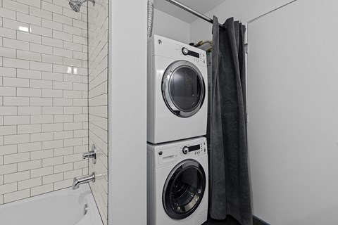 a small laundry room with a washing machine and a shower