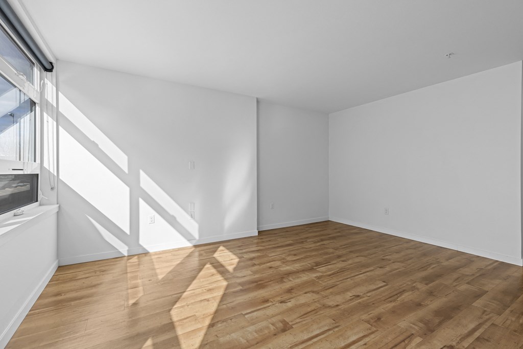 an empty room with white walls and wooden floors