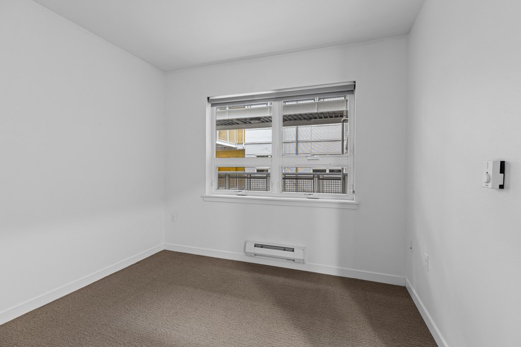 room with a window and white walls and carpeting