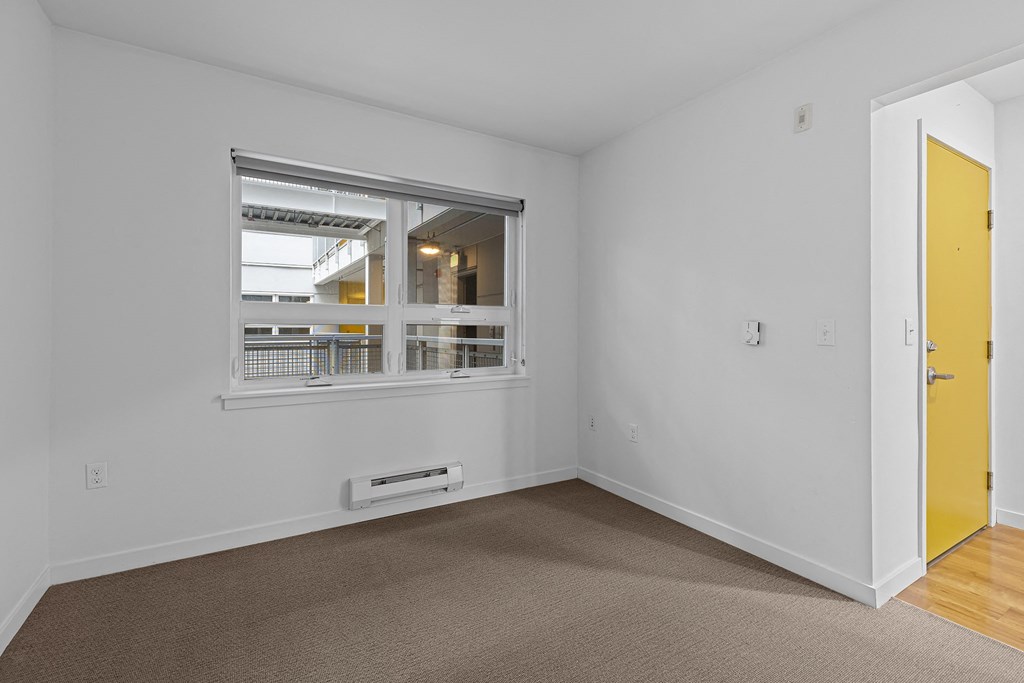a living room with a window and a yellow door