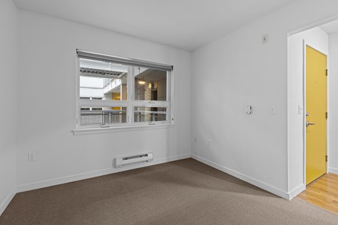 a living room with a window and a yellow door