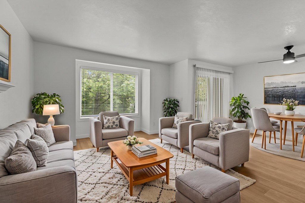 A living room with a grey couch, a coffee table, and a dining table.