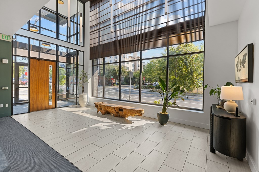 a lobby with large windows and a wooden bench