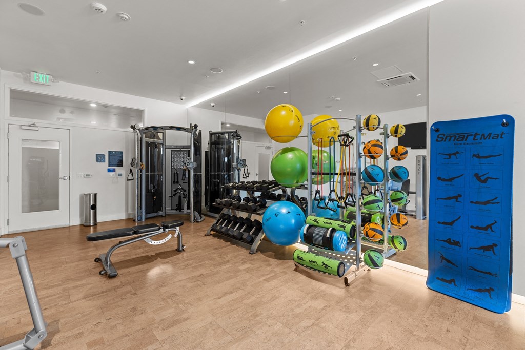 a gym with weights and other exercise equipment on a wooden floor