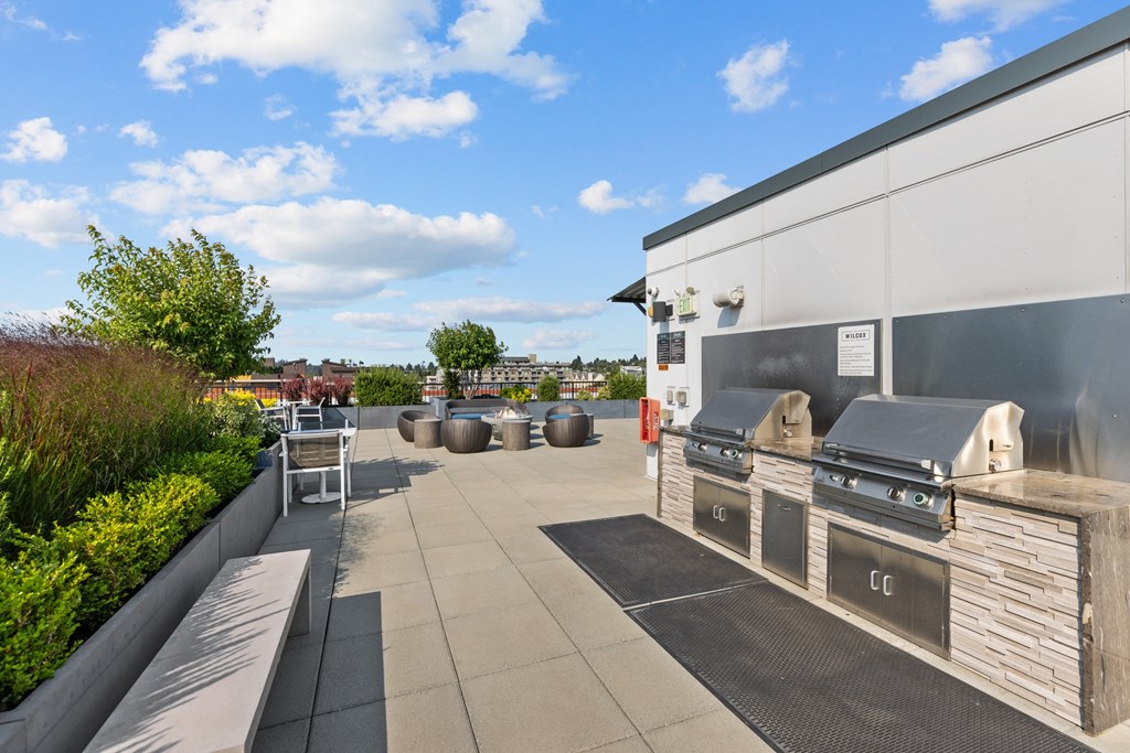 the outdoor patio of a home with a barbecue grill and seating