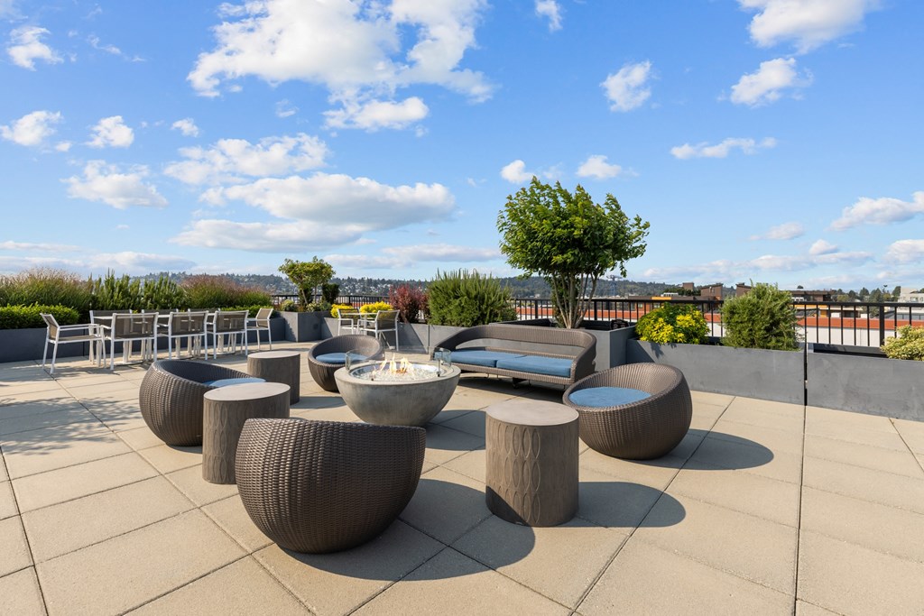 a seating area on the roof of a building with tables and chairs