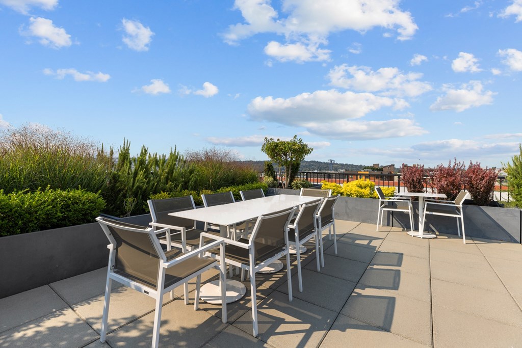 a patio with tables and chairs on the roof of a building