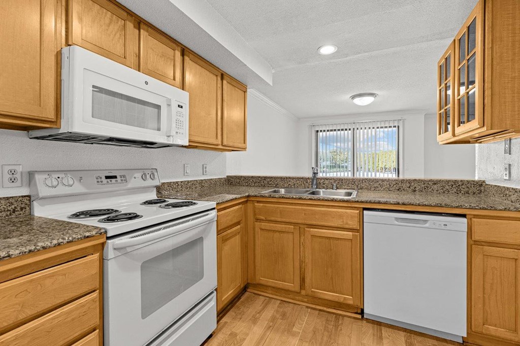 A kitchen with wooden cabinets and white appliances.