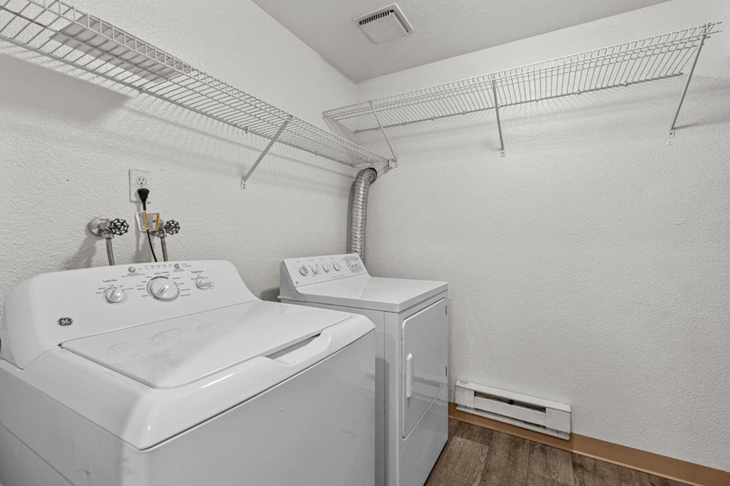 A white washing machine and dryer in a small laundry room.