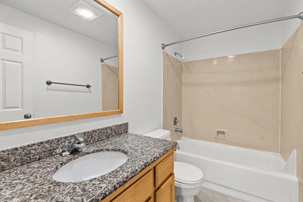 A bathroom with a sink, toilet, and bathtub.