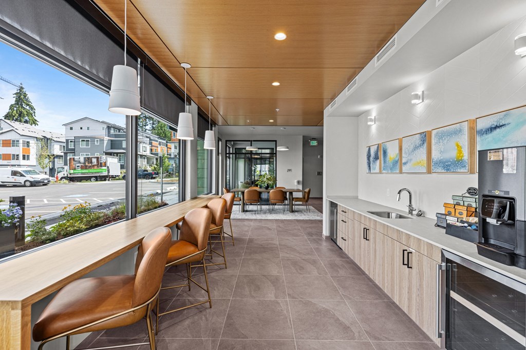 a kitchen with a bar and chairs in front of a window