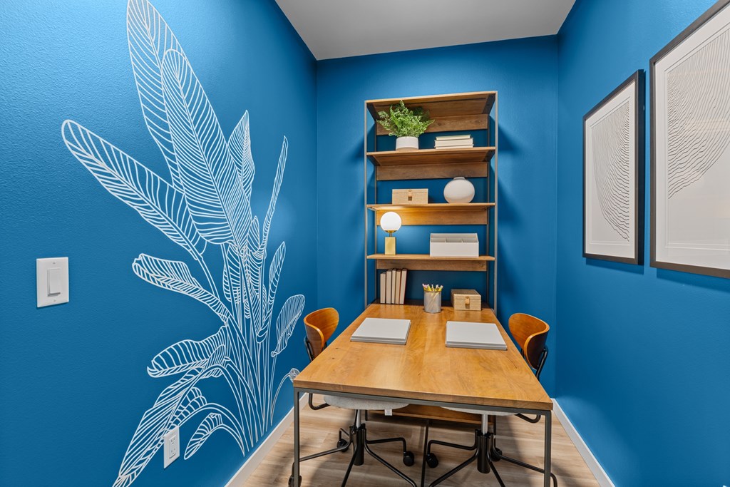 a conference room with blue walls and a wooden table and chairs