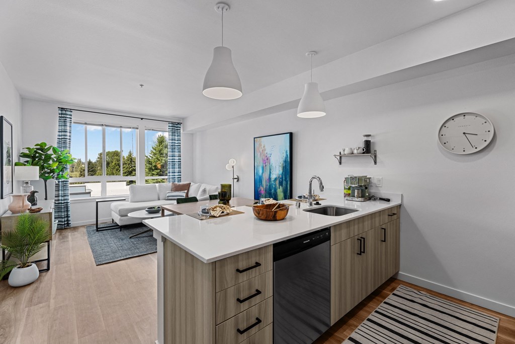 a kitchen with an island and a living room with a clock