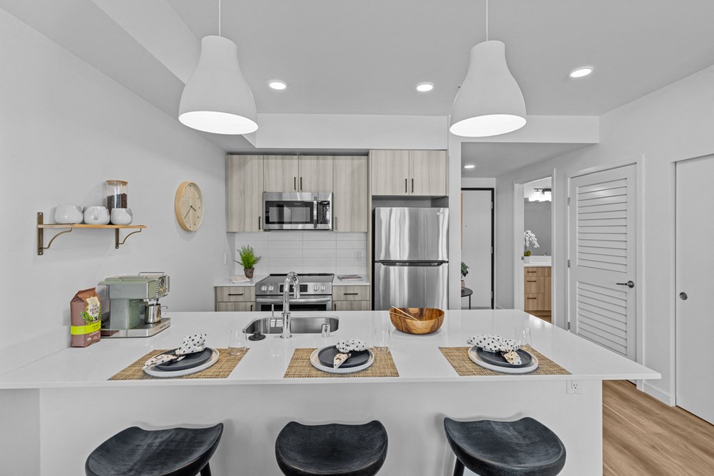 a kitchen with a large island and a stainless steel refrigerator