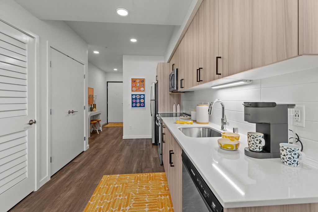a kitchen with white countertops and a stainless steel sink