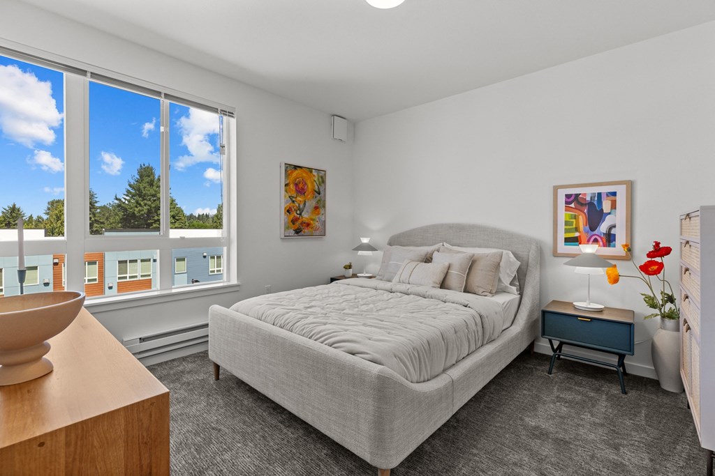 a bedroom with a bed and a large window