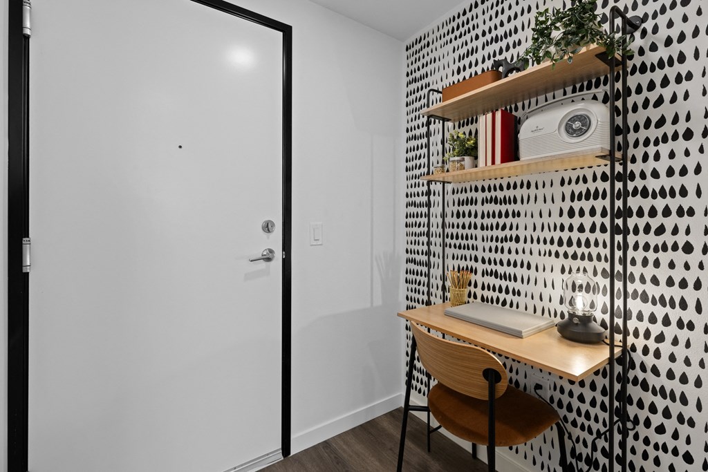 a small desk in a room with a white wall and a door