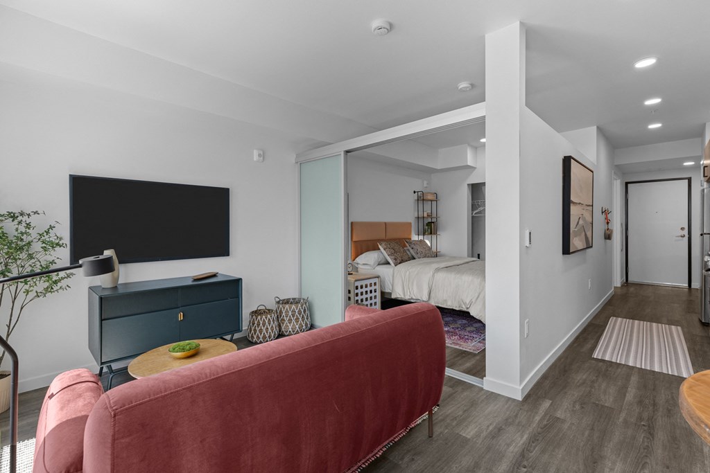 a living room with a couch and a bed in a bedroom