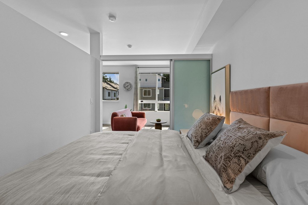 a bedroom with a large bed and a living room with a couch