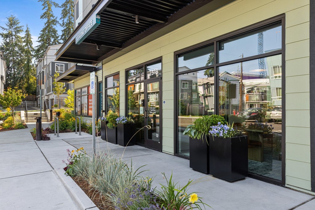 a sidewalk in front of a building with large glass windows