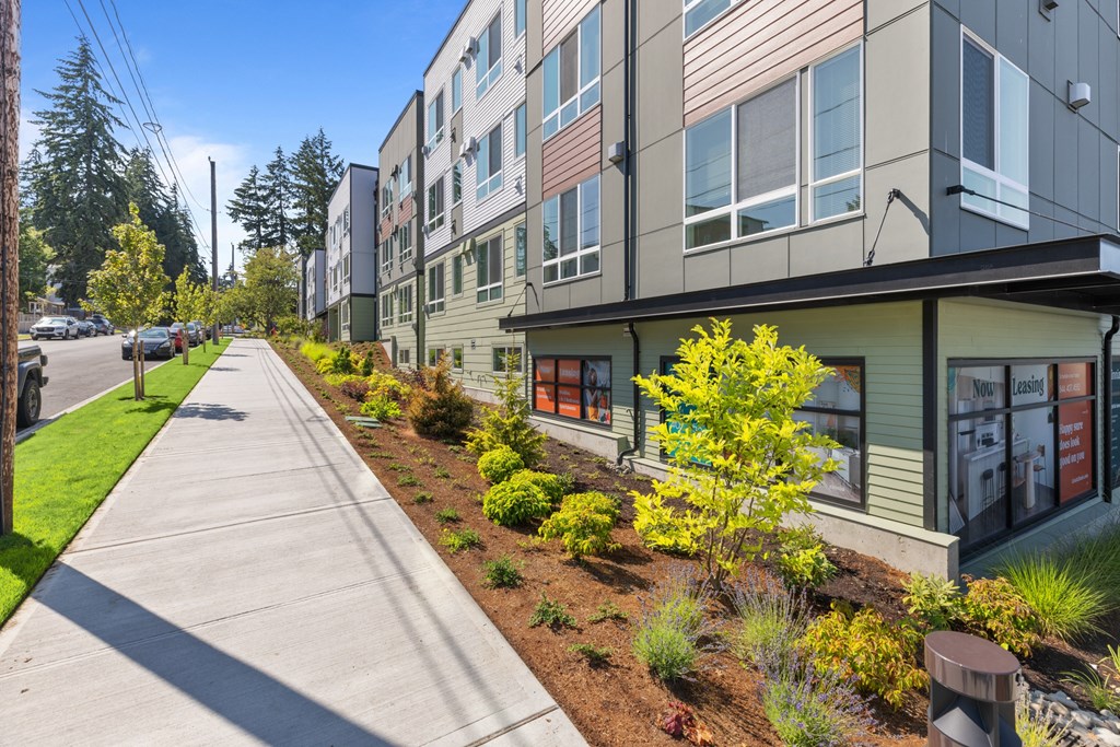 new apartment buildings on the side of a sidewalk