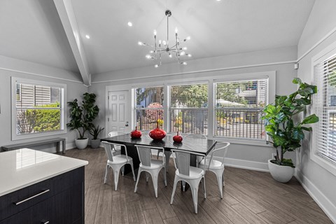 a dining room with a table and chairs and a large window