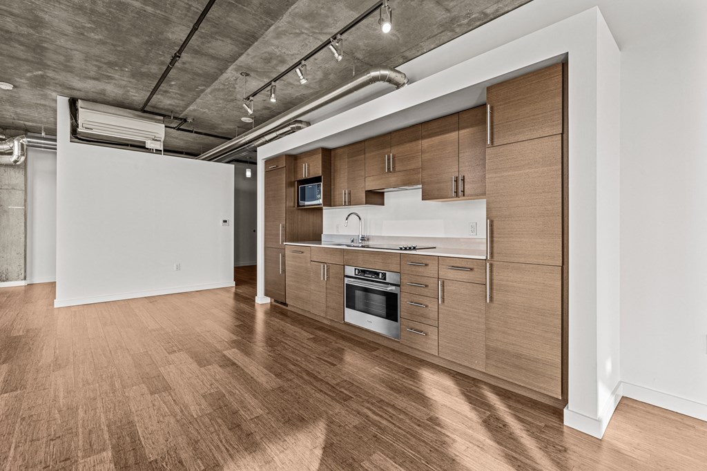 a kitchen with wood floors and wooden cabinets and white appliances