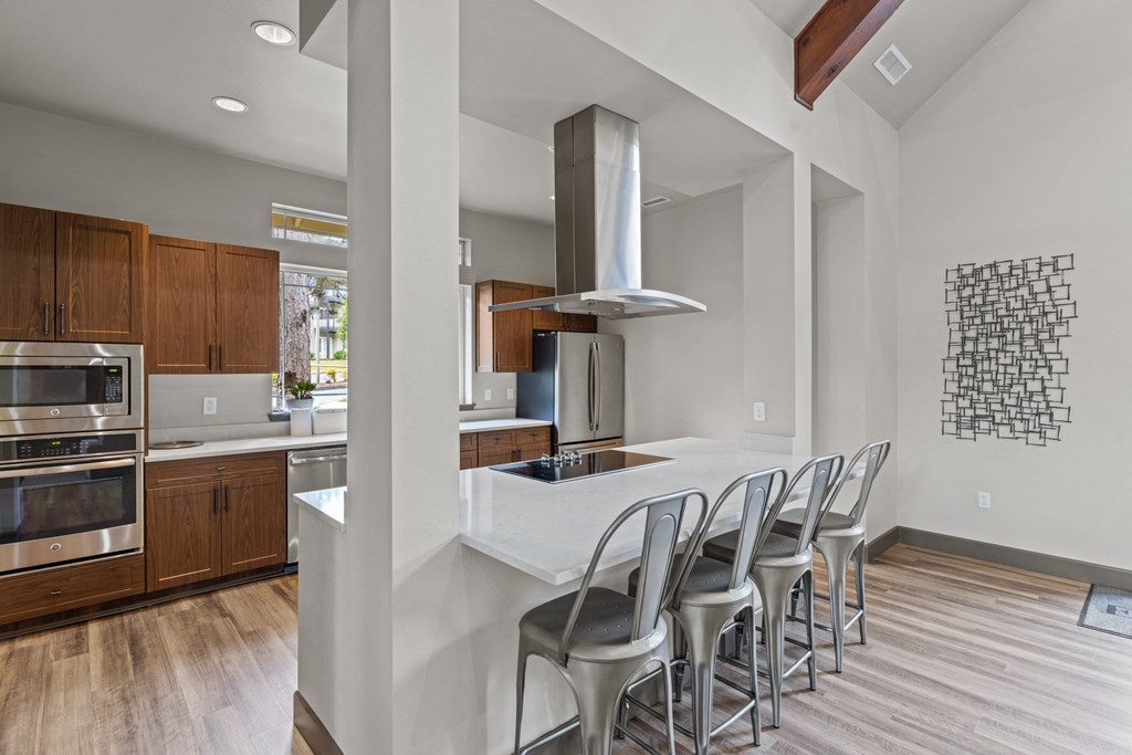 a kitchen with white countertops and wooden cabinets