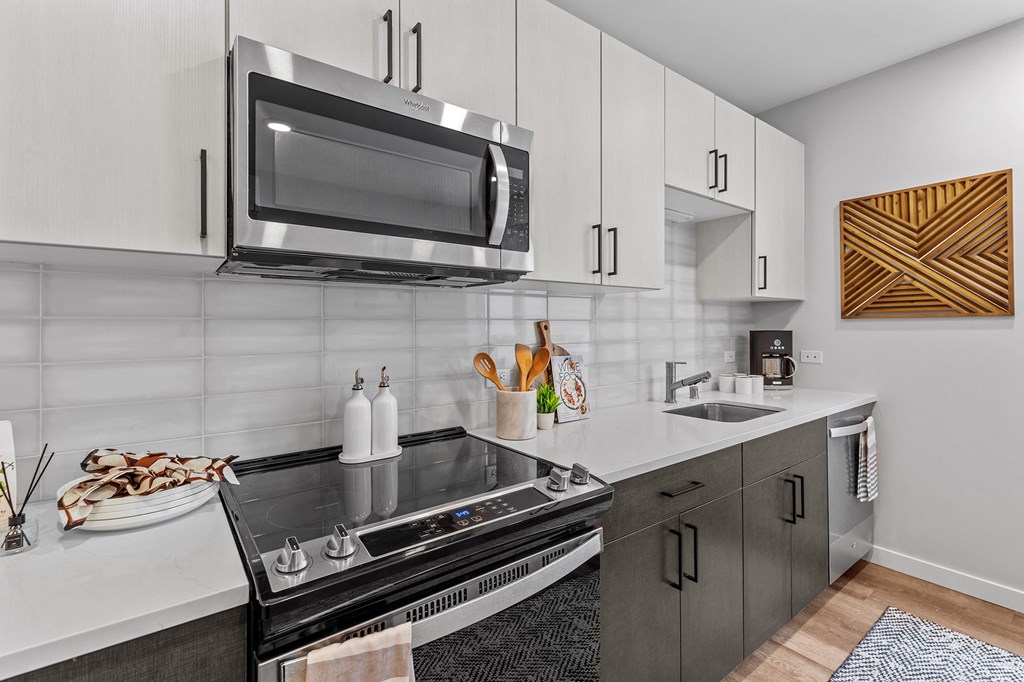Gridline Apartments Kitchen with Stainless Steel Appliances and White Cabinets