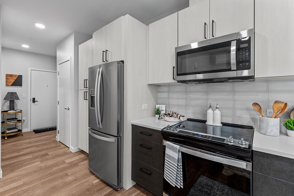 Gridline Apartments Kitchen with Stainless Steel Fridge and Entryway