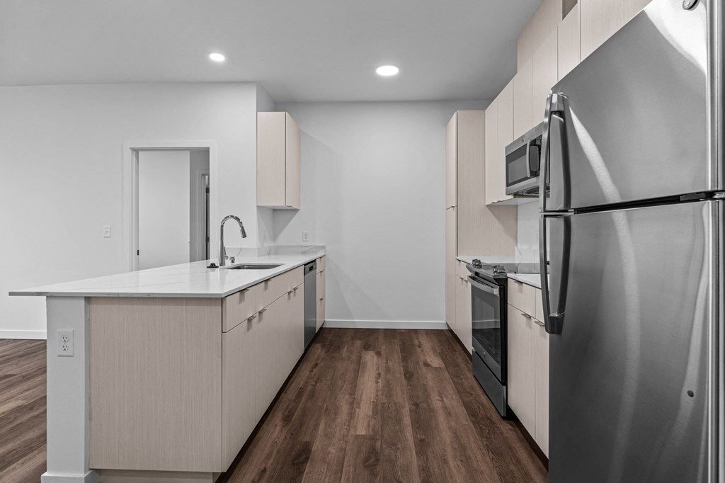 a renovated kitchen with white cabinets and stainless steel appliances