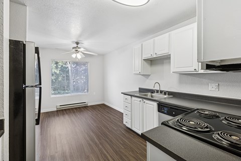 A kitchen with a black stove top oven and white cabinets.