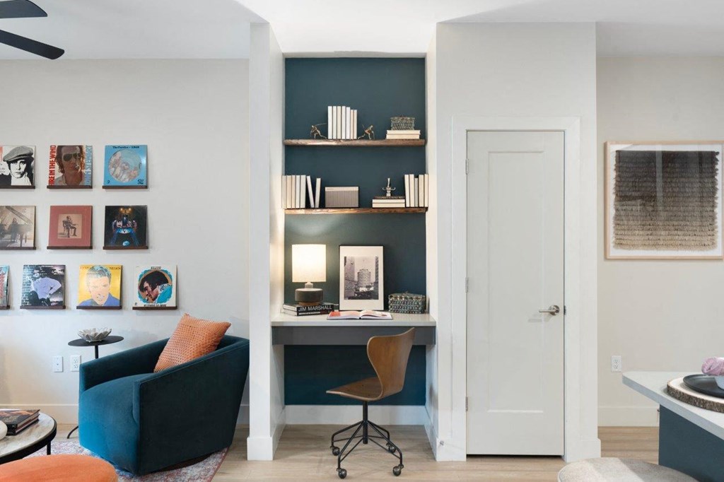 a home office with a blue wall and a desk and a chair