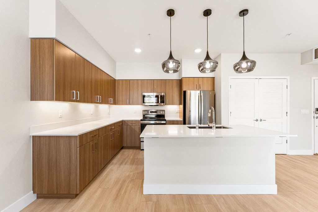 a kitchen with a large white island and wooden cabinets