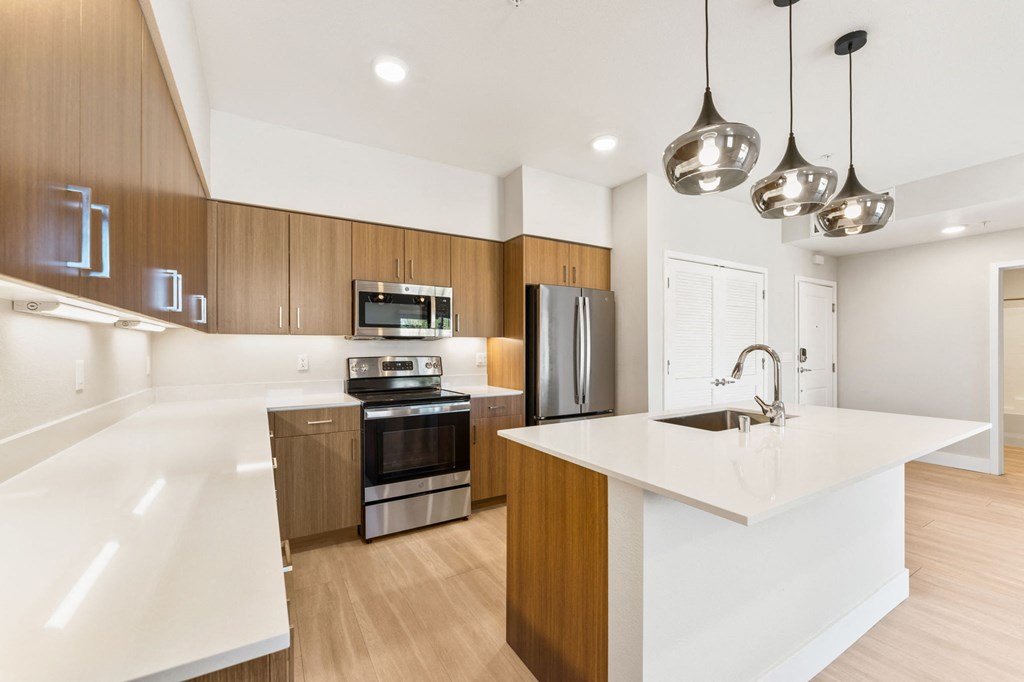 a white kitchen with wooden cabinets and stainless steel appliances