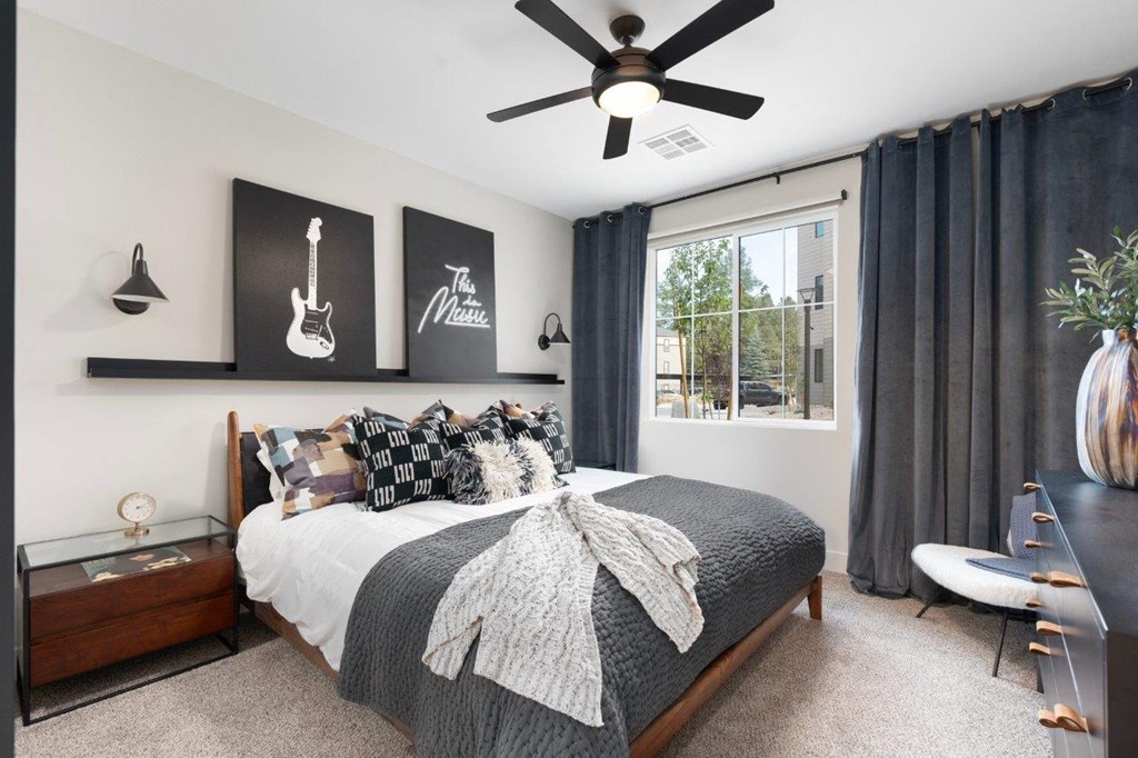 a bedroom with a bed and a ceiling fan