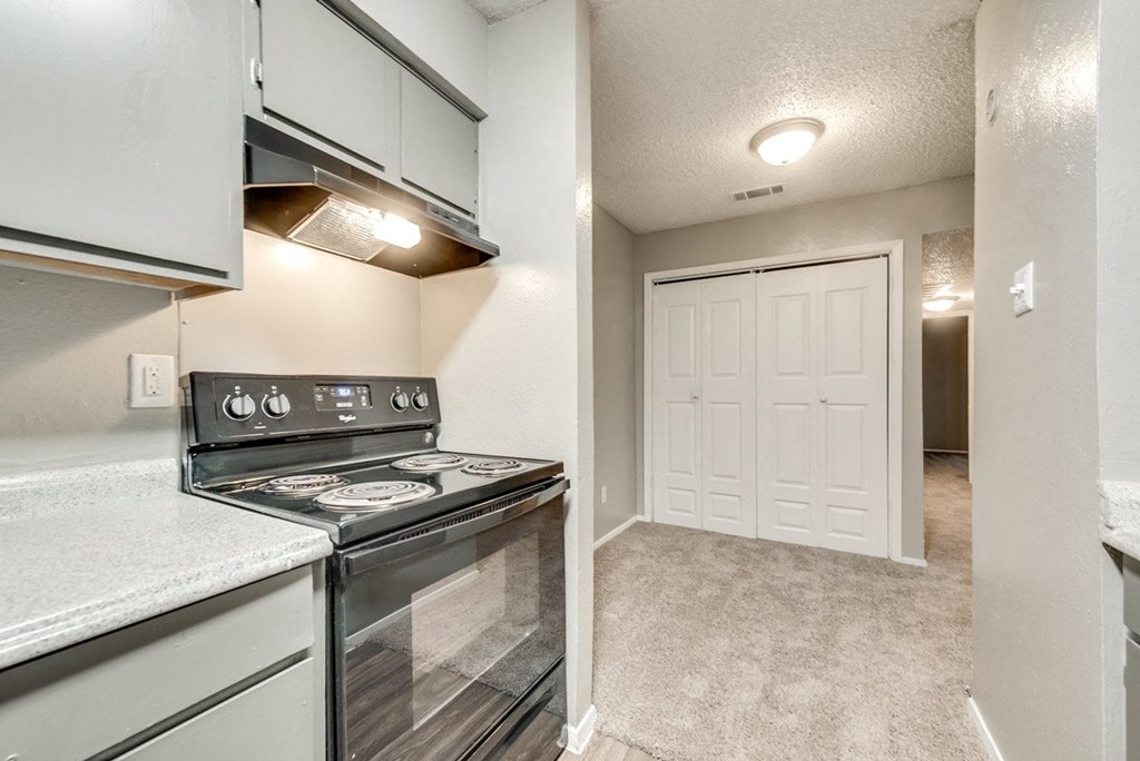 an empty kitchen with a stove and a white door