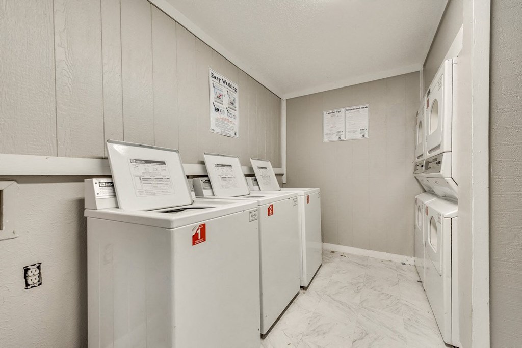 a laundry room with white appliances and white walls