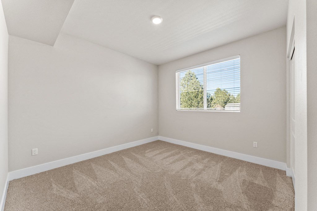 an empty room with carpet and a window