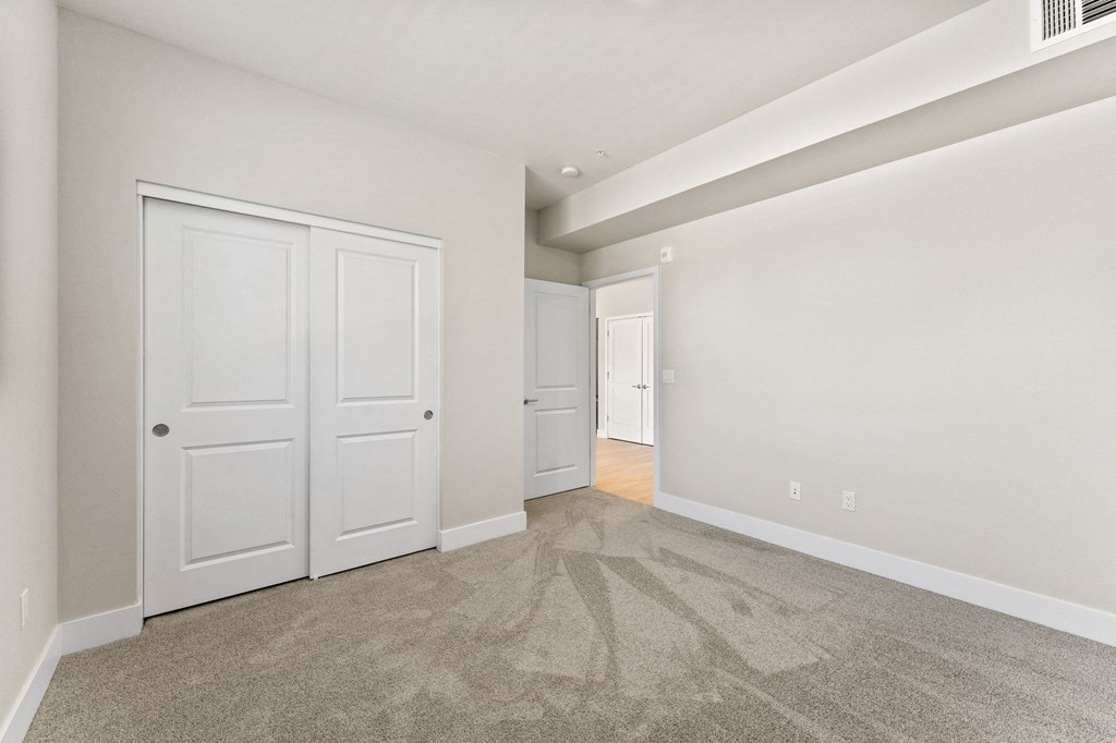 the living room of a new home with white doors and carpet