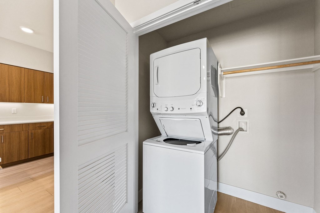 a laundry room with a washer and dryer and a door to a kitchen
