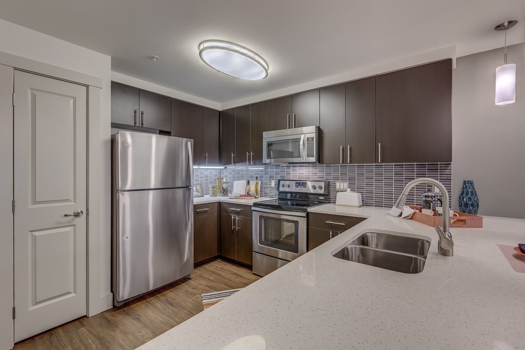 a kitchen with stainless steel appliances and white counter tops