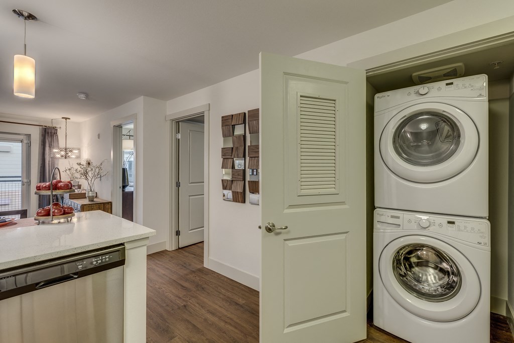 a washer and dryer in a kitchen with a door to the laundry room