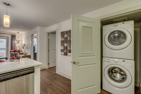 a washer and dryer in a kitchen with a door to the laundry room