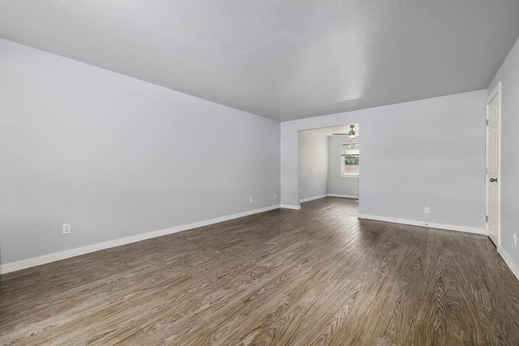North River Apartments living room and dining room of an empty house with wood floors