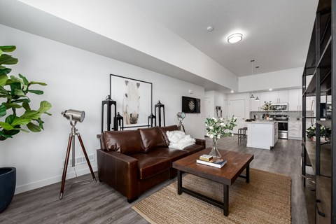 A living room with a brown leather couch and a wooden coffee table.