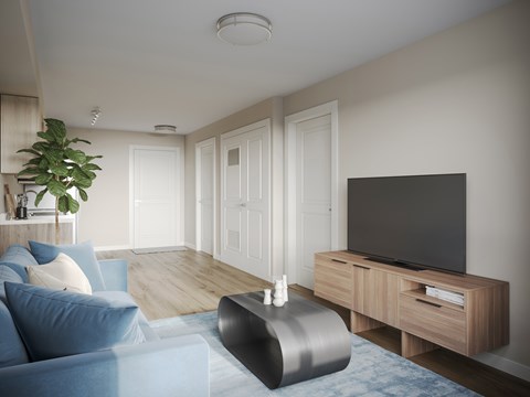 A modern living room with a blue couch and a television on a wooden stand.