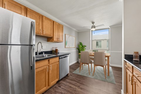 A kitchen with wooden cabinets and a stainless steel refrigerator.