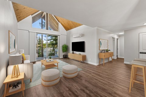 A living room with a white couch and a wooden floor.