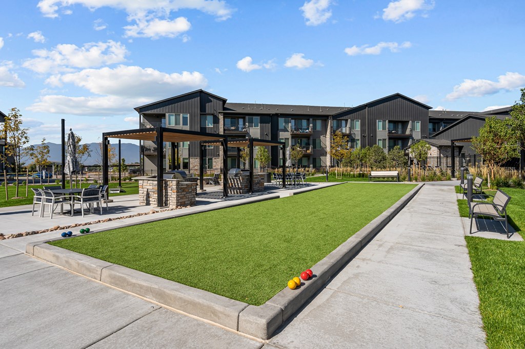 a yard with lawn chairs and a building in the background